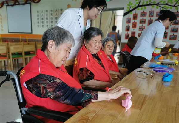 當地北溝養老服務中心的老人們用彩泥制作手工。新沂融媒供圖