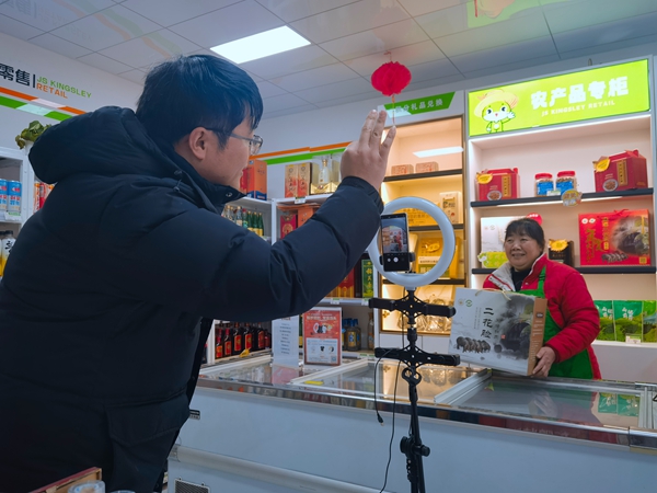 志愿者協助店主鄒國英直播。常州煙草供圖