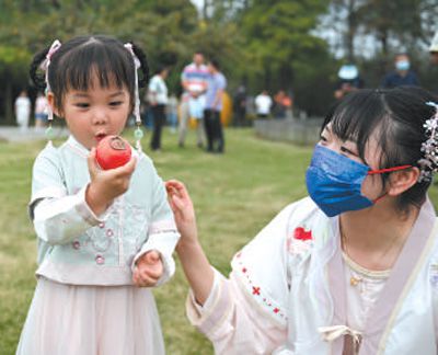 浙江省杭州市西溪國家濕地公園探索保護與利用雙贏之路。圖為小朋友在火柿節上品嘗火柿。  新華社記者 黃宗治攝